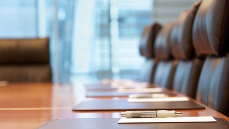 会議室のイメージ 長テーブルにペンと用紙が並べてあります。
