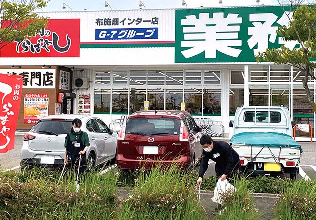 布施畑インター店の周辺のゴミを拾い集めるスタッフ
