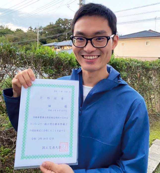 男性が笑顔で技能検定の合格書を持っている